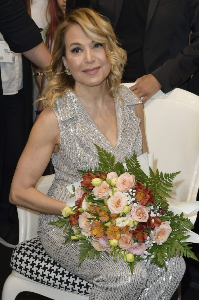 Barbara D'Urso, in elegante tailleur gilet pantalone in micro-paillettes argento