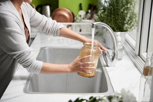 ragazza che riempie un vaso di fiori con acqua